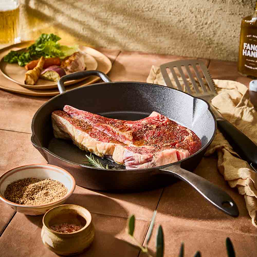 steak in a cast iron frypan with helper handle - House