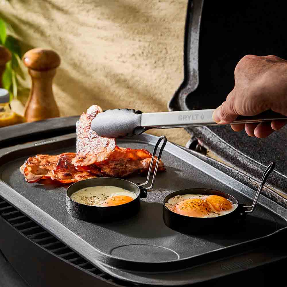 man picking up bacon using long handled BBQ tongs - House