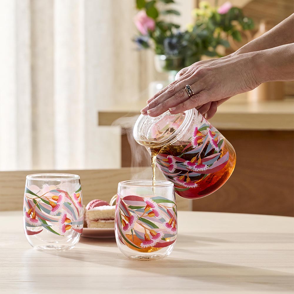 woman pouring tea into a gumnut design glass mug