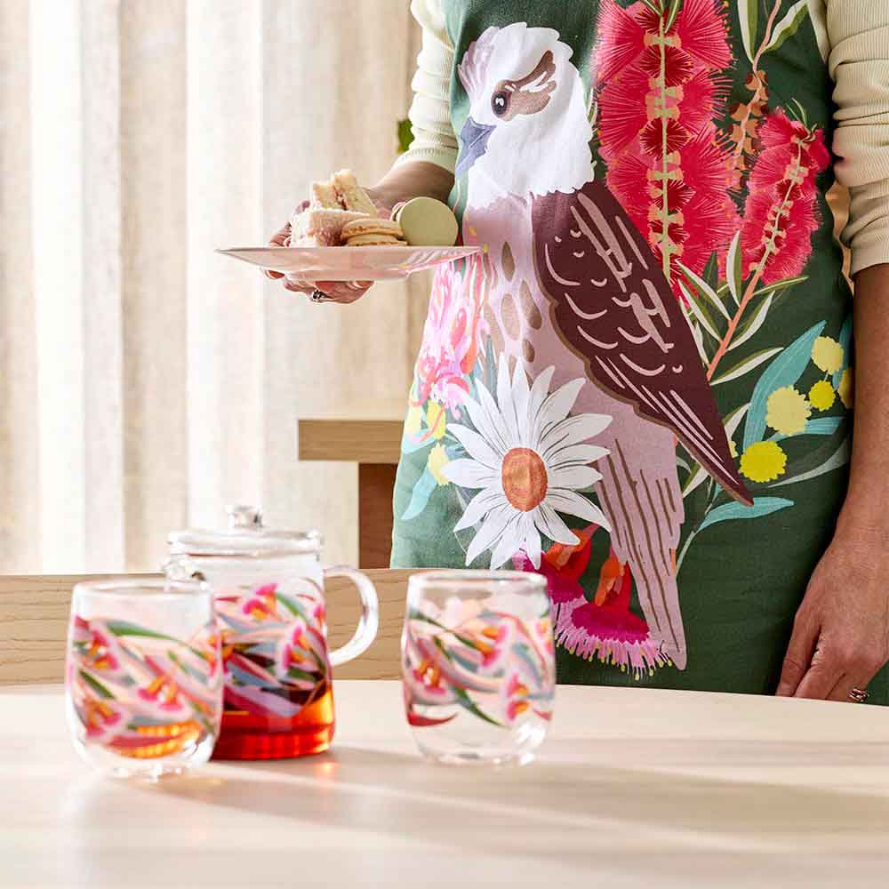 woman wearing a green apron with a kookaburra design
