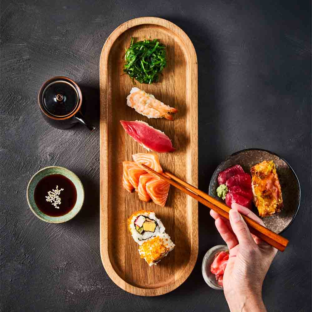 person picking up sashimi with chopsticks