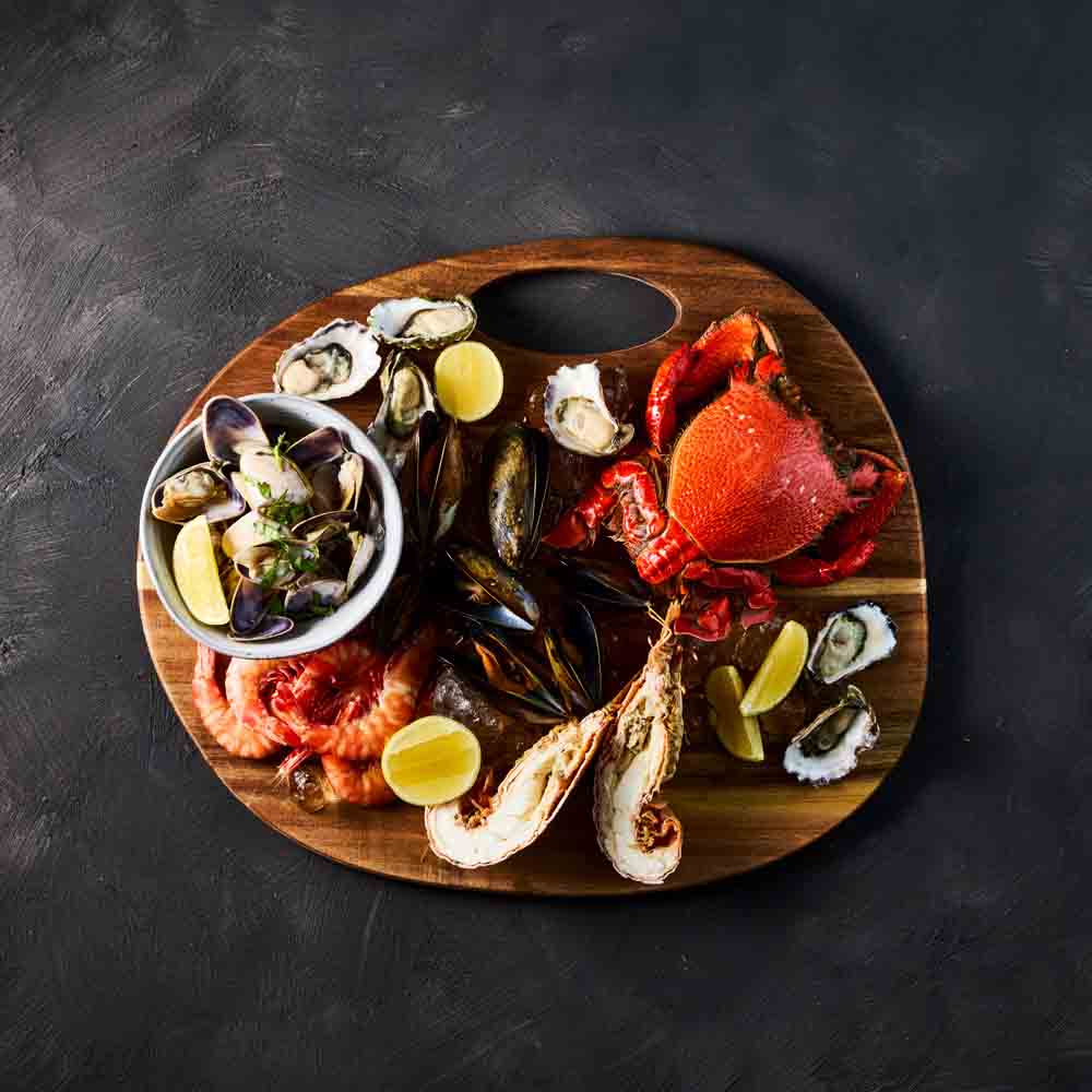seafood platter on a round wooden serving board