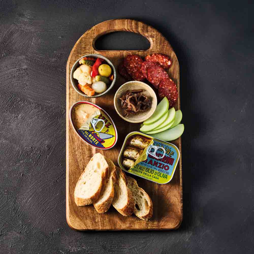 platter of sardines, pate and chorizo on wooden board