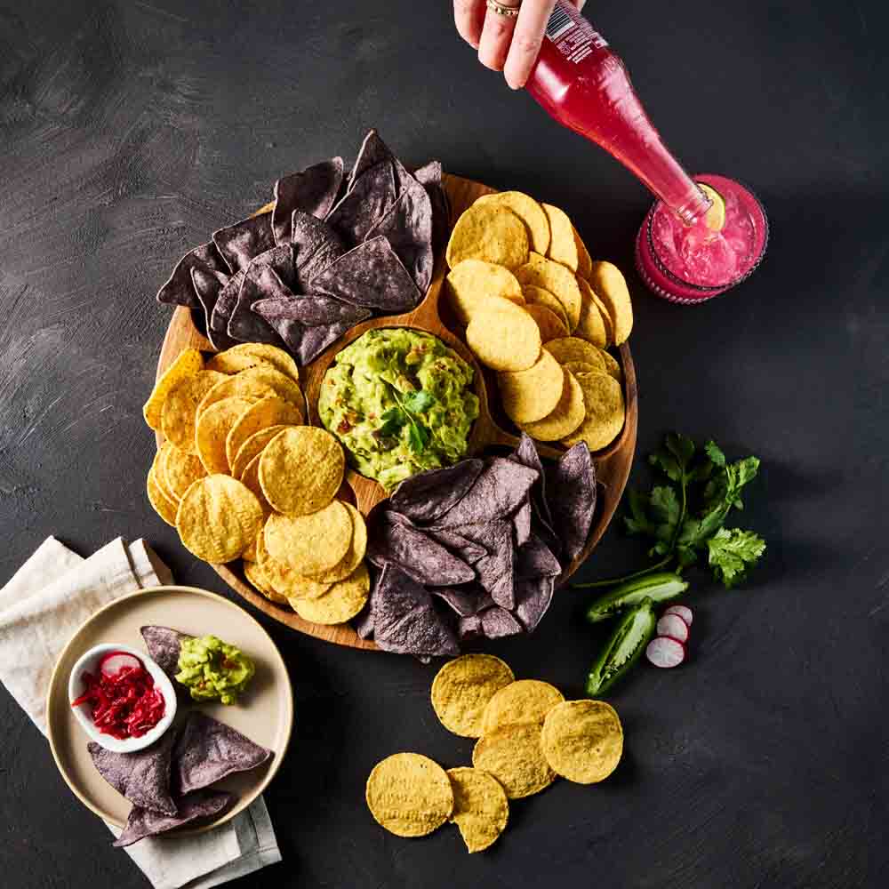 divided platter of dip and chips with black background