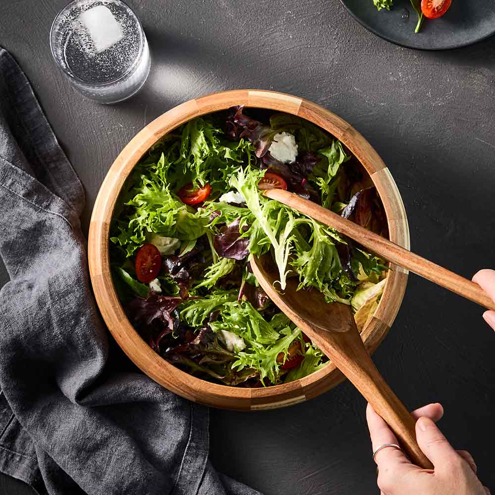 garden salad in wooden serving bowl with wooden serving spoons