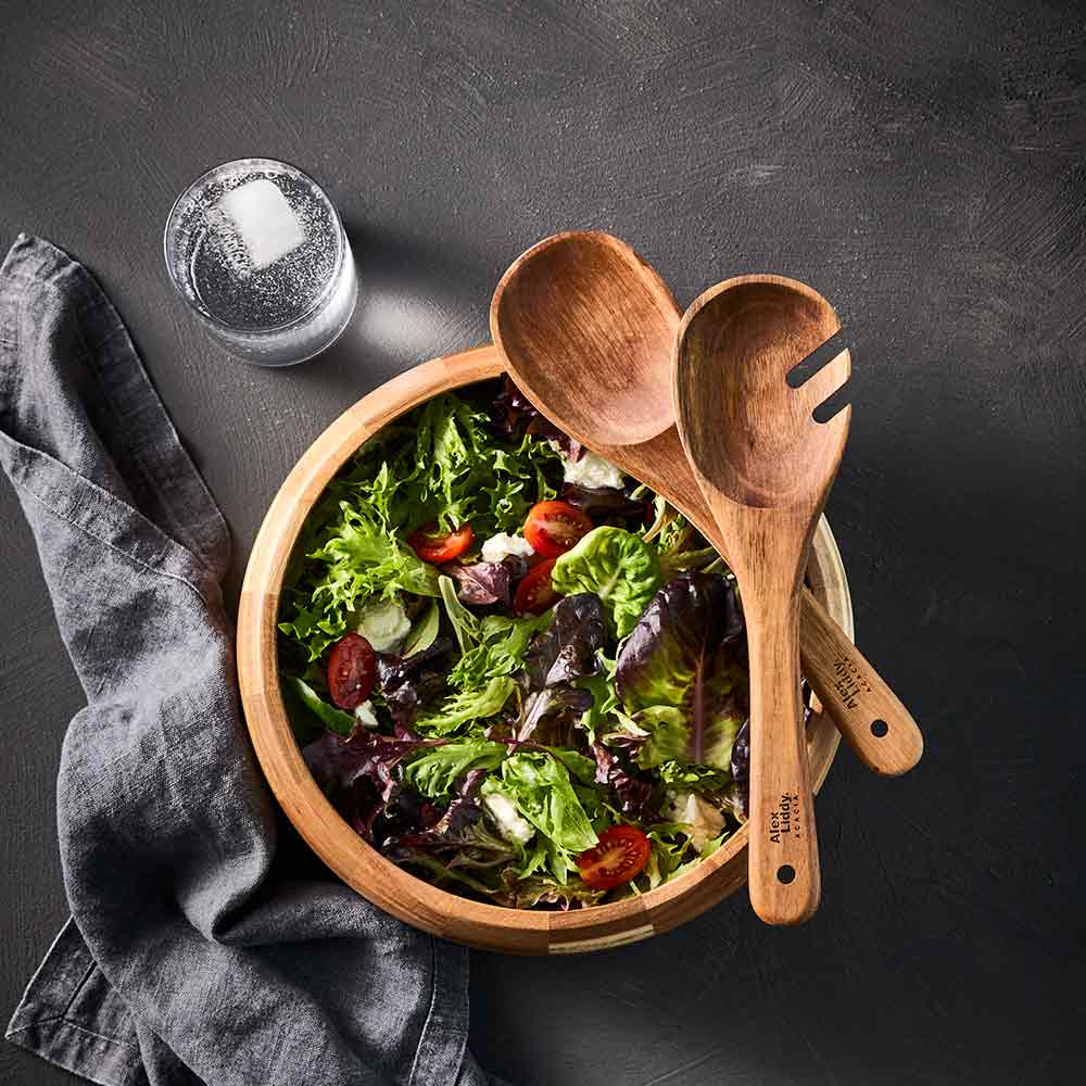 garden salad in wooden serving bowl with wooden serving spoons