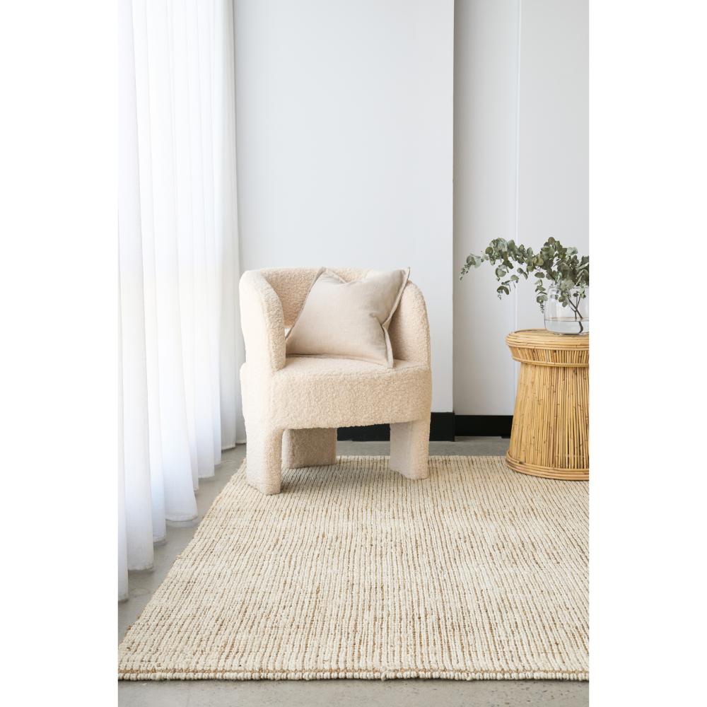 Cream white jute rug with boucle chair and wicker table - House