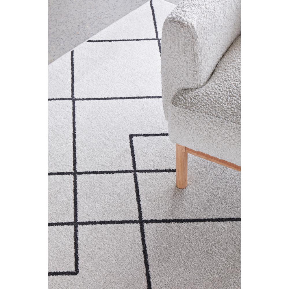 grey modern abstract rug with boucle chair - House