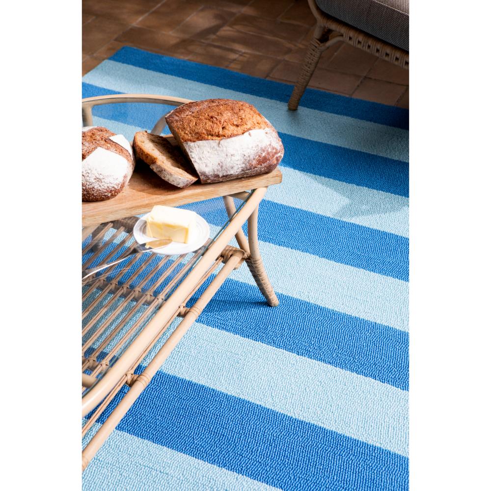 blue striped rug under coffee table with bread - House