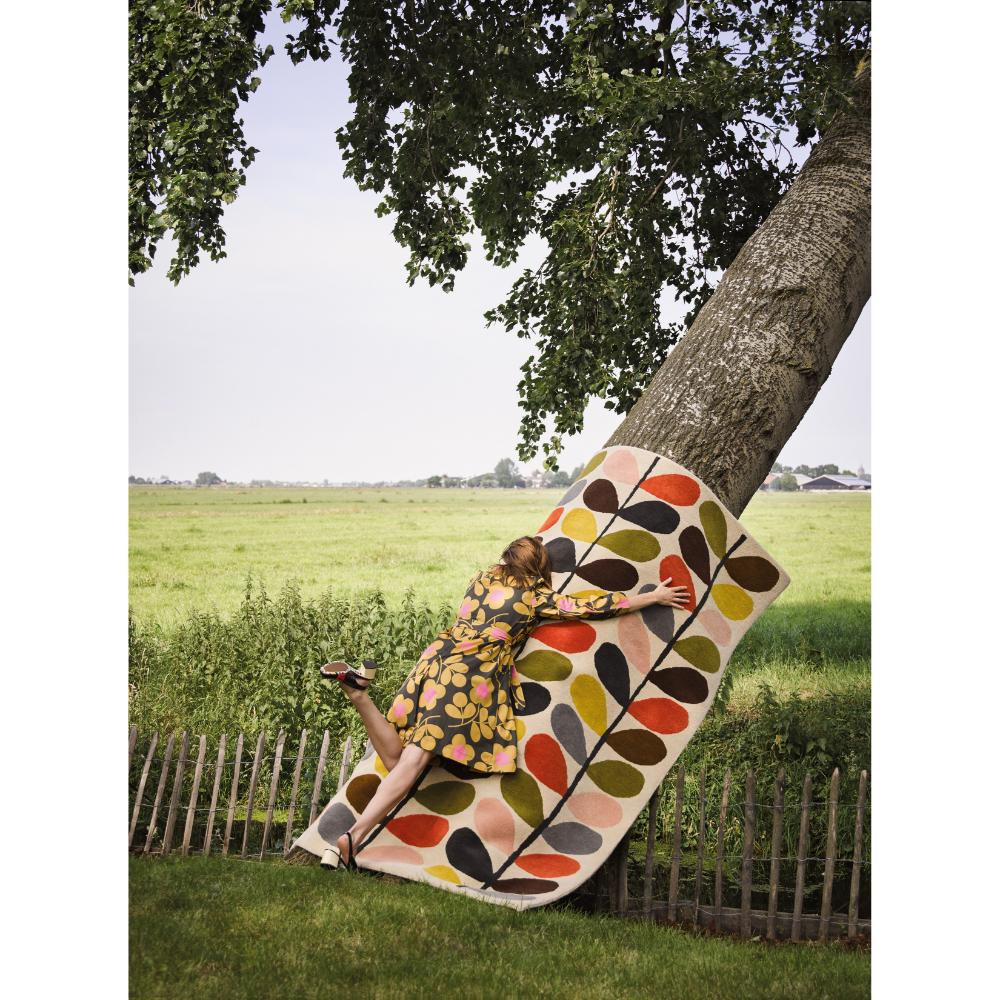 woman hugging flower rug on a tree - House