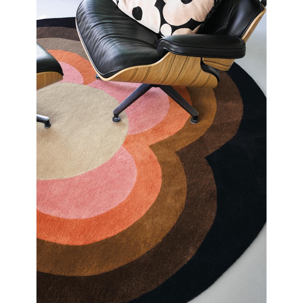 round pink and brown flower rug with black armchair - House