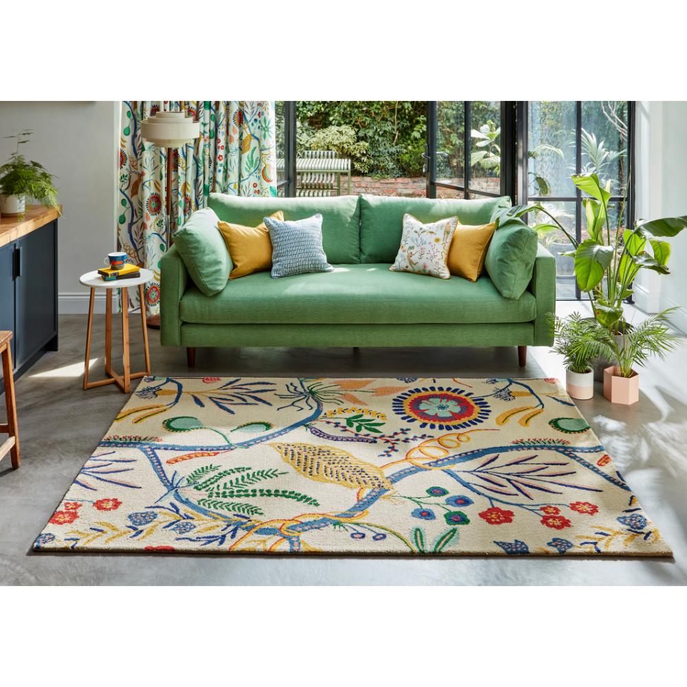 multicolour floral rug with green couch in loungeroom - House