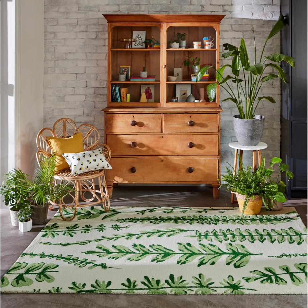 Green fern wool rug with wicker chair in sitting room - House