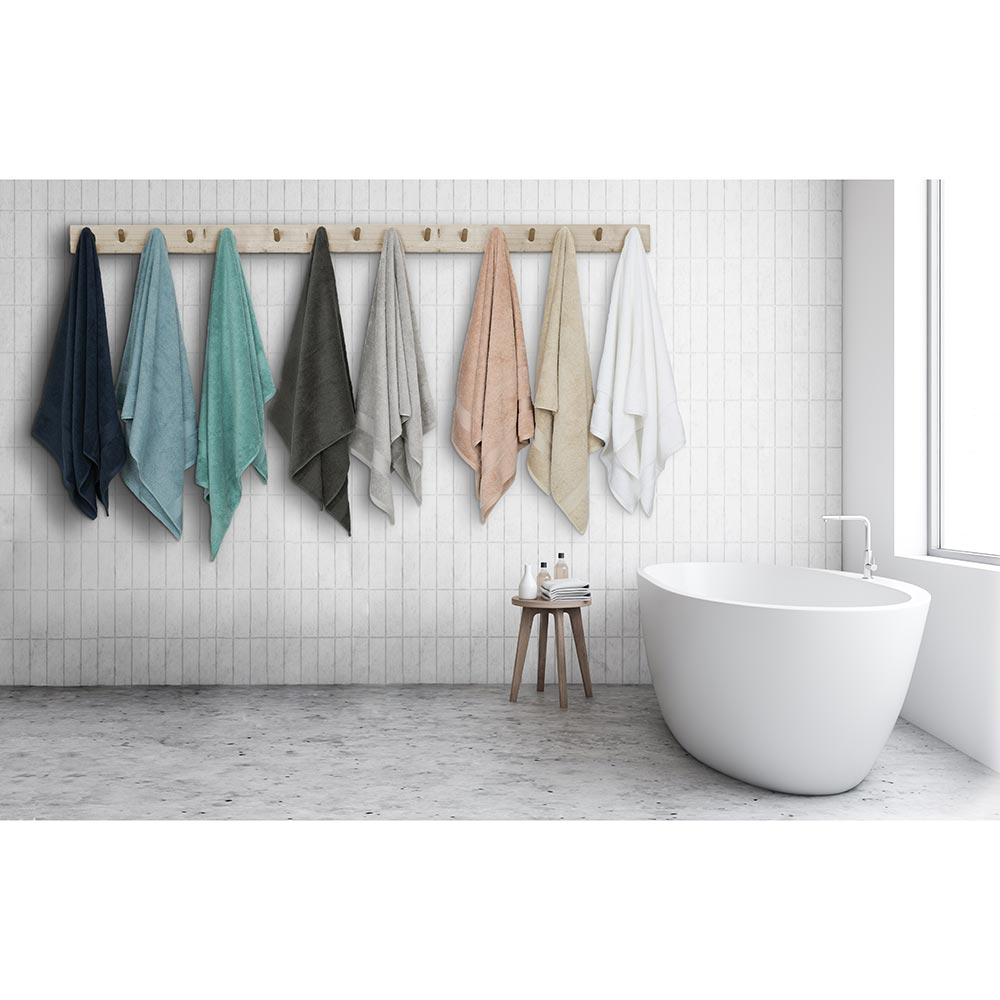 Algodon St Regis Bath Towels at House. Bath towels hanging wooden hooks next to a bath.