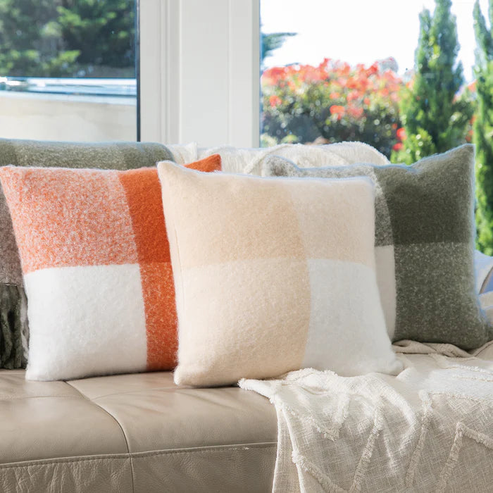 Decorative pillows on a sofa with a blurred outdoor background