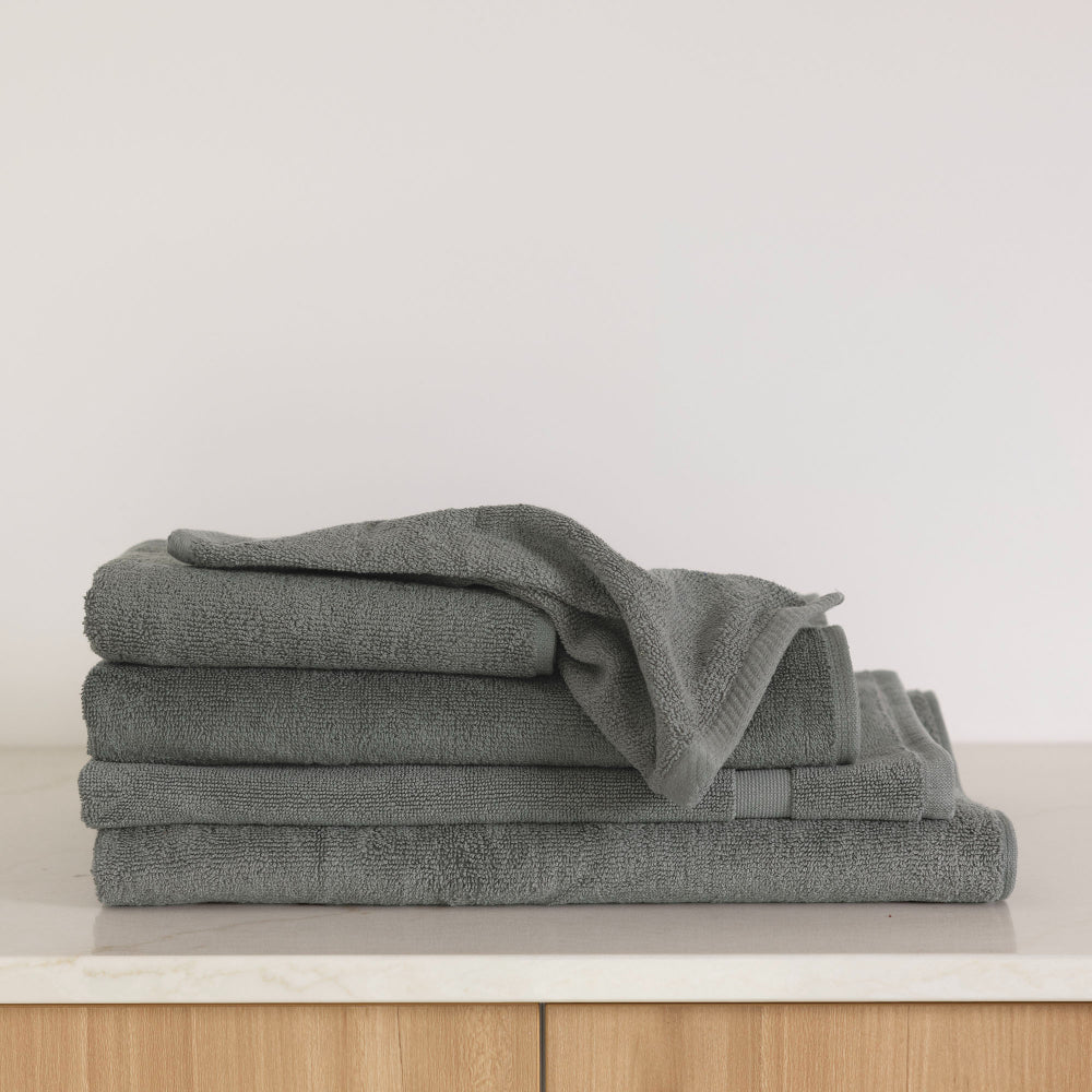 The Bambury Chateau bath range in charcoal shown folded with items including the bath sheet, bath towel, bath mat, and hand towel.