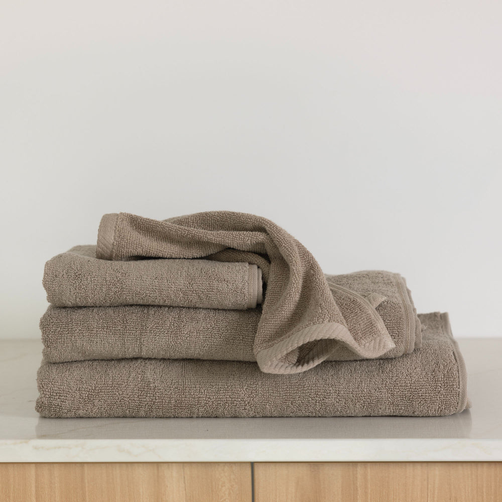 The latte Bambury Chateau bath range folded showing the items across the set including the bath sheet, bath towel, bath mat, hand towel and face washer.