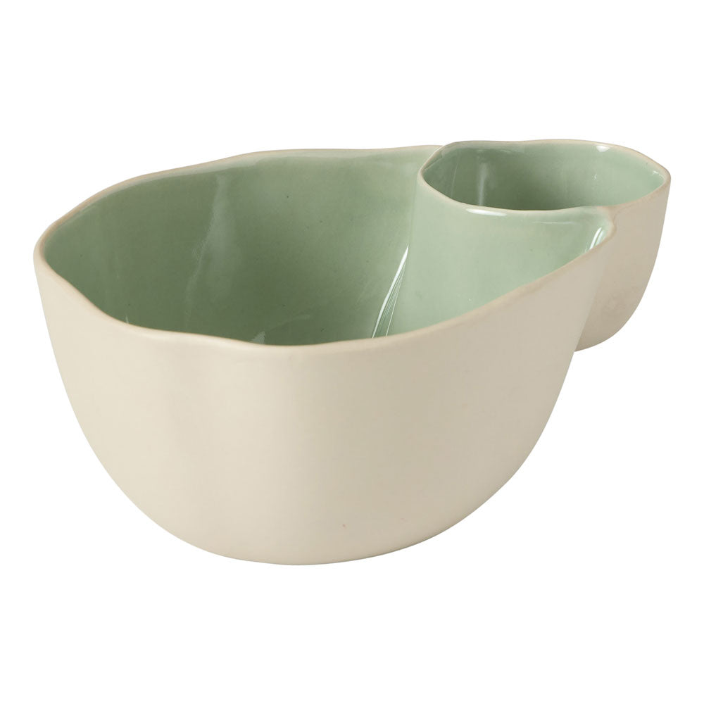 The Ecology Selvedge olive bowl features one large section and a smaller section with a cream exterior and a glossy green interior.
