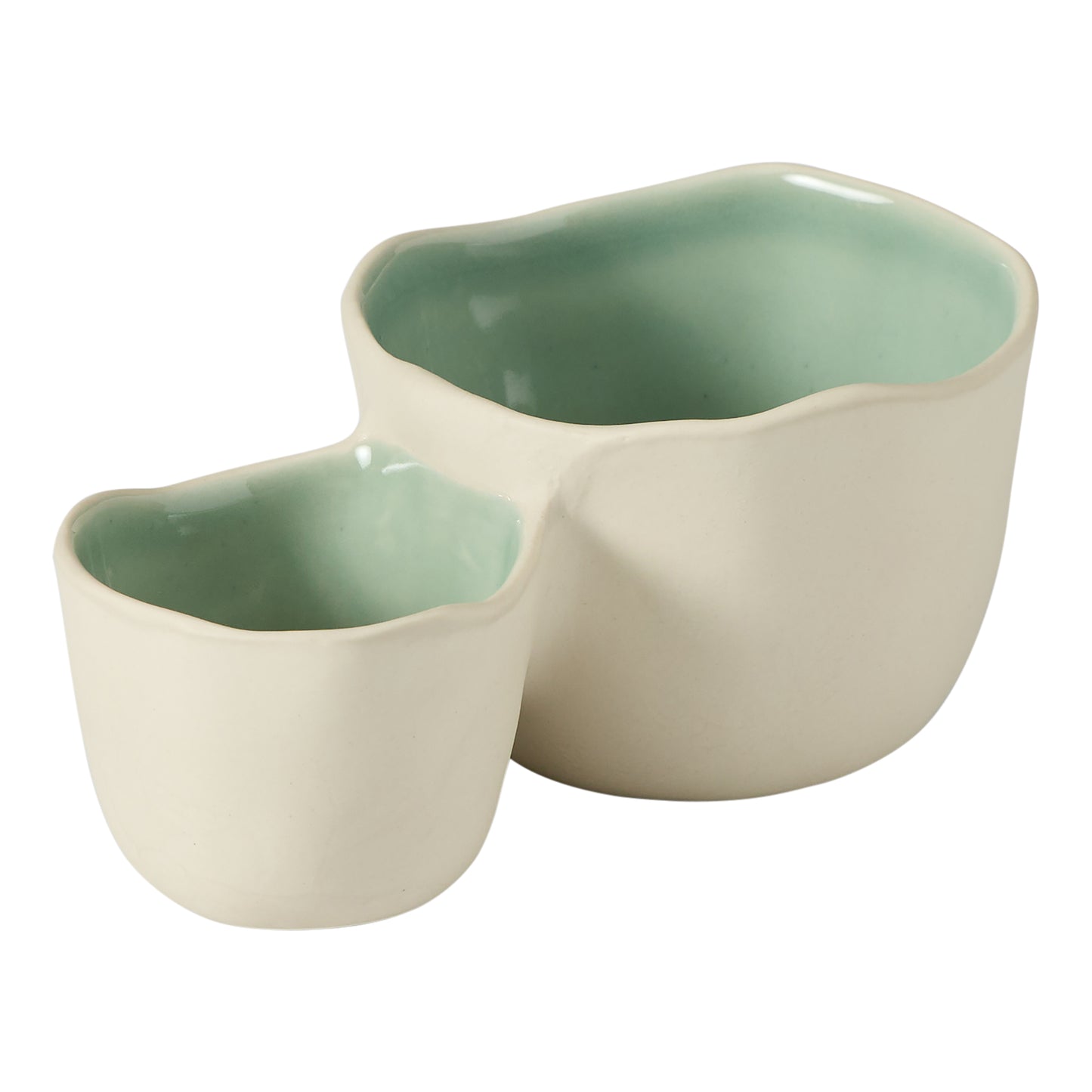The Ecology Selvedge salt and pepper pinch bowls feature two bowls fused together, one larger and one smaller with a cream exterior and a green glossy interior.
