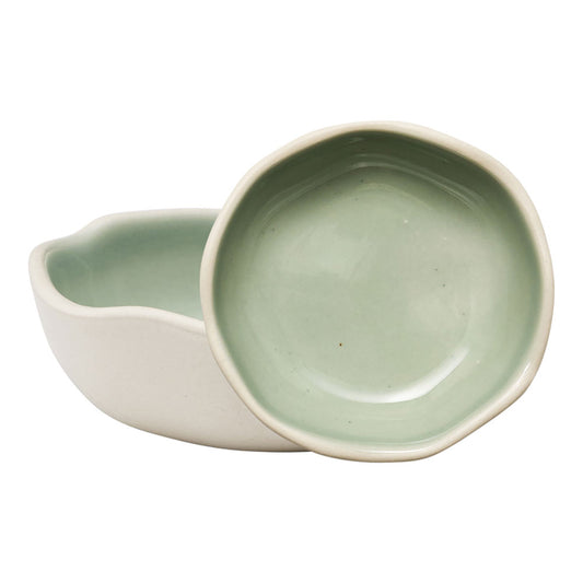 The Ecology Selvedge set of 2 dip bowls featuring a curved edge with the cream exterior and a glossy green interior finish.