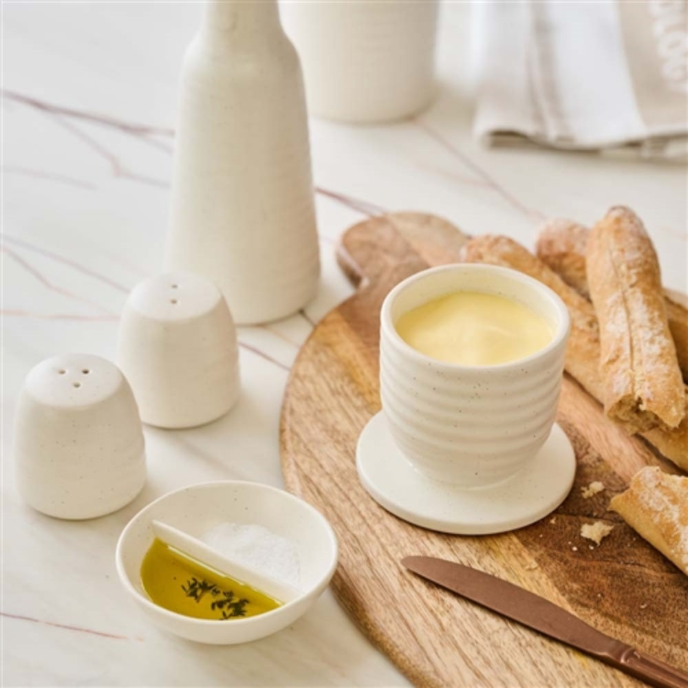 The Ottawa salt dish with olive oil on one side and salt on the other next to a board with bread. 