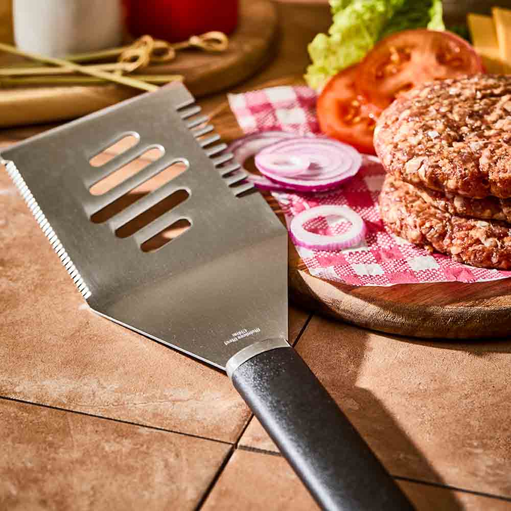 stainless steel BBQ turner next to burger patties - House
