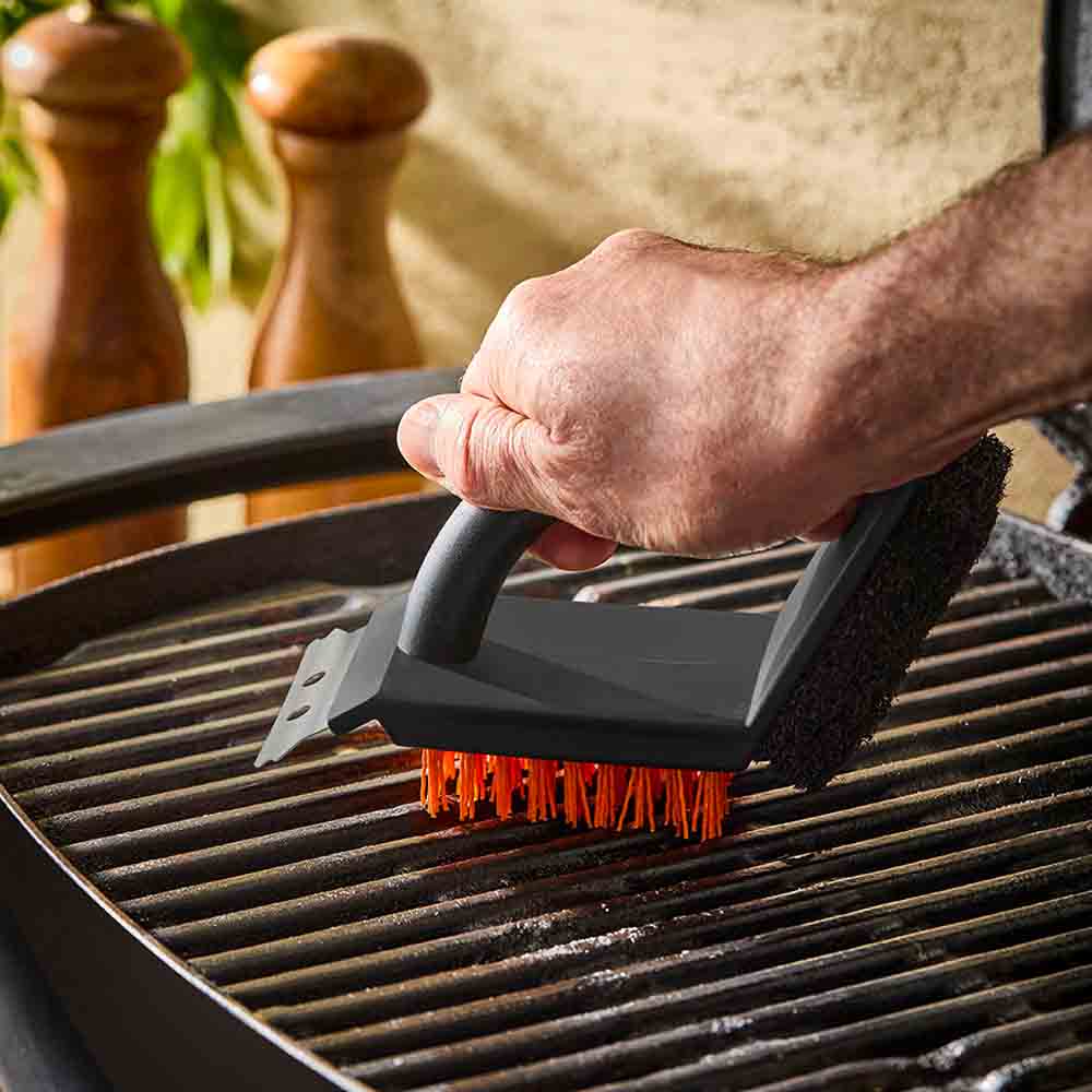 man using 3-in-1 grill brush to clean barbeque - House