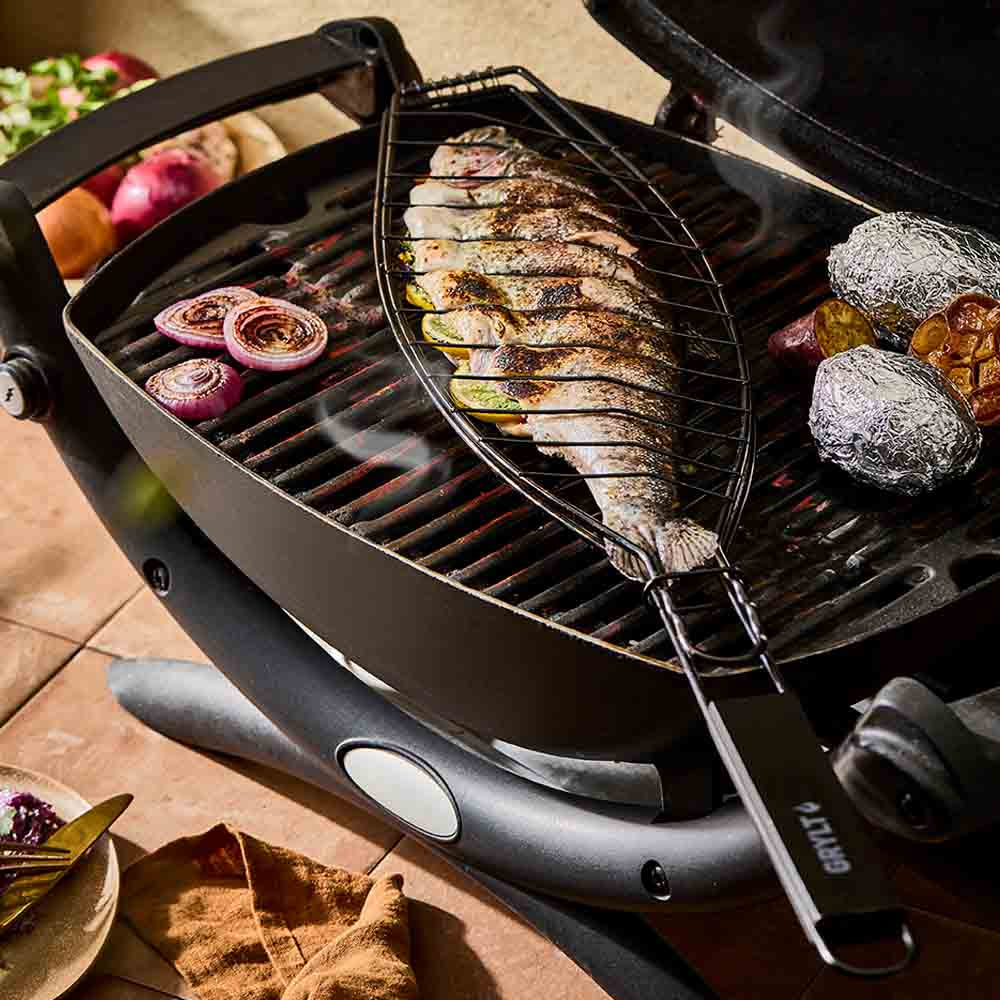 Full fish grilling in a steel fish basket on the BBQ - House