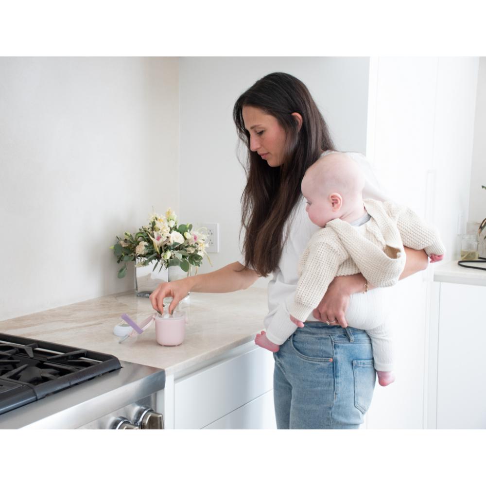 woman with baby preparing baby formula - House