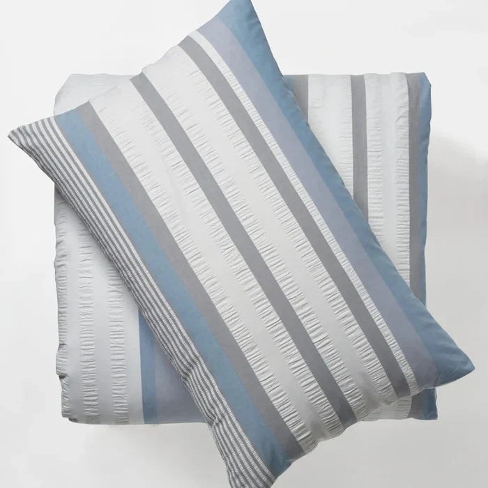 Striped pillowcases with blue and gray stripes on a light gray background