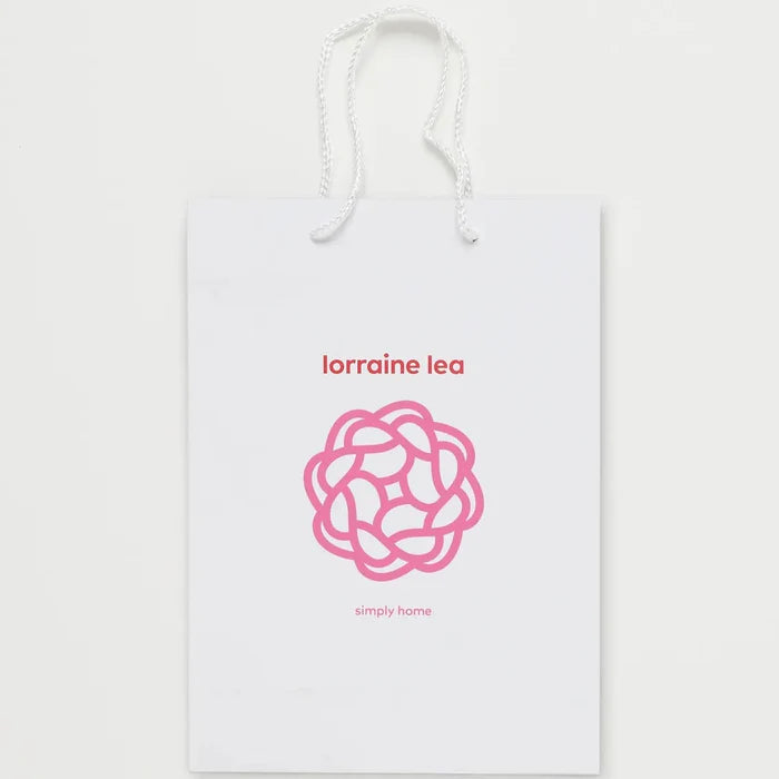 White product packaging with pink logo and text on a white background