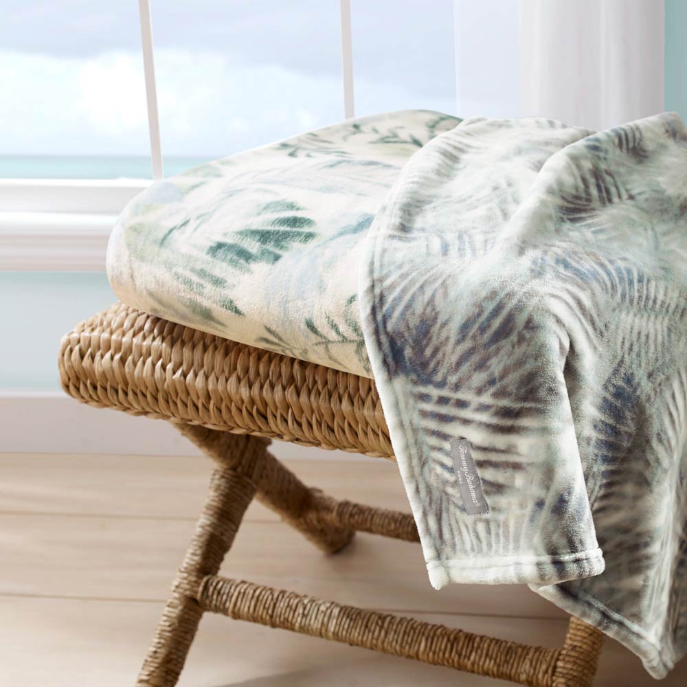 Tommy Bahama Wallpaper Leaves Throw Green folded on a chair at House