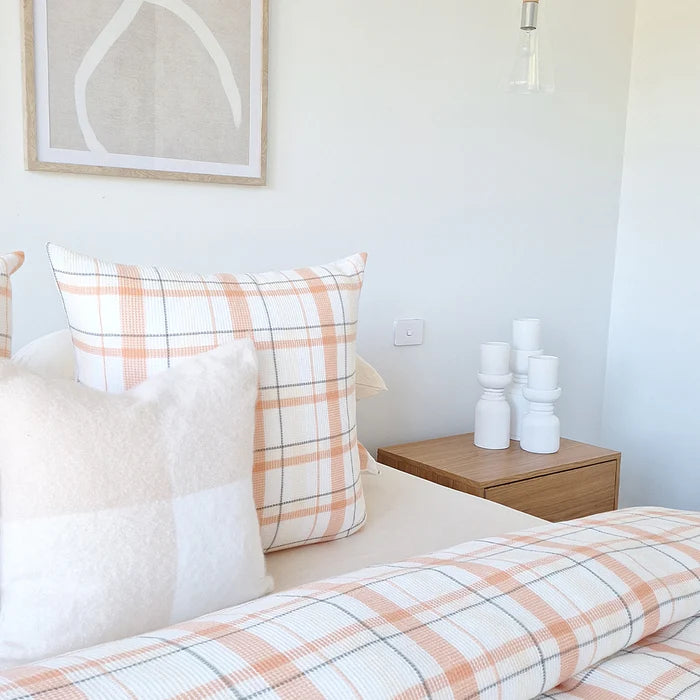 Bed with plaid bedding and pillows in a bedroom setting.