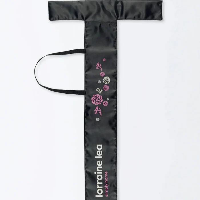 Black garment bag with floral designs and 'loraine lea' branding on a white background