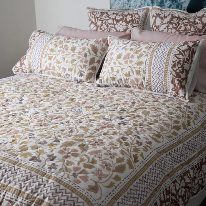 Patterned bedspread and pillows on a bed