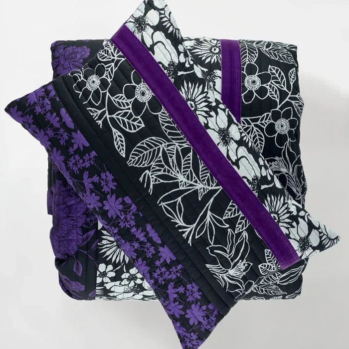 Folded fabric with purple and black floral patterns on a white background