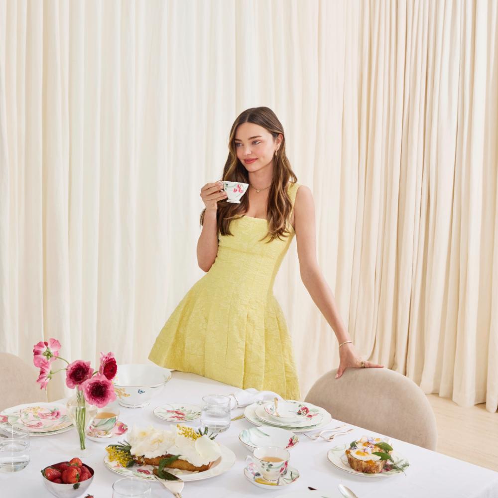 Miranda Kerr standing by the table drinking tea