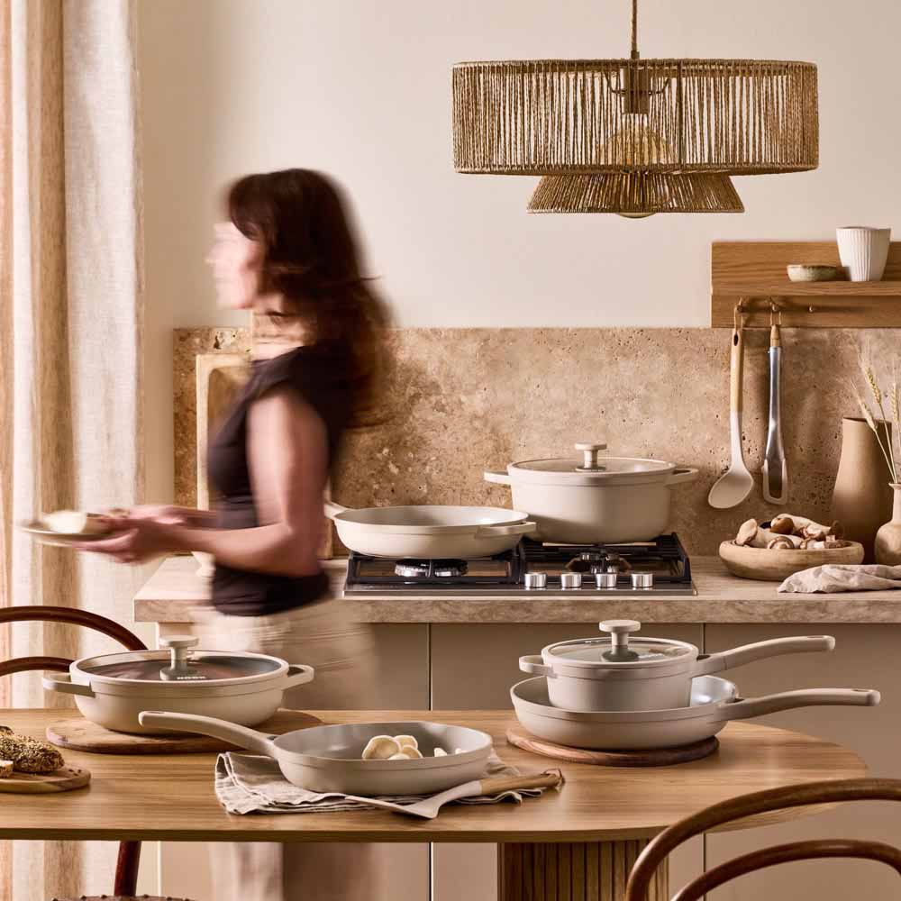 woman walking through a cream theme kitchen
