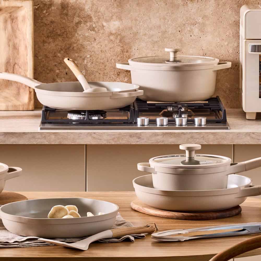 range of cream cookware, frypans, and saucepans