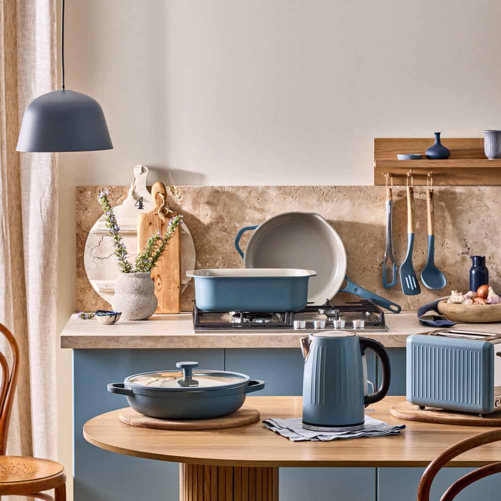 range of blue cookware and appliances in a blue themed kitchen