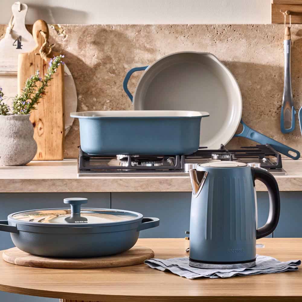 range of blue cookware and kettle in a blue themed kitchen