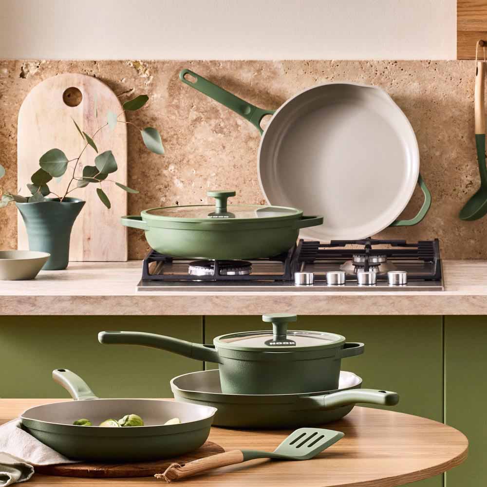 range of green frypans, saucepans and utensils