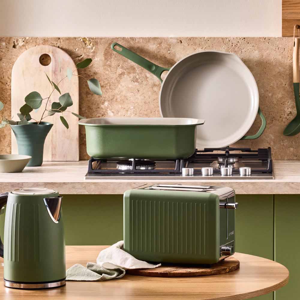 range of green cookware and kettle in a green themed kitchen