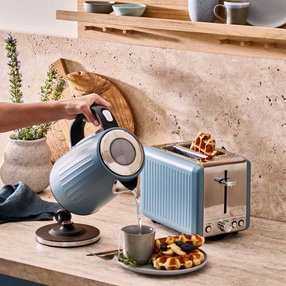 water poured from blue kettle and blue toaster on the kitchen counter