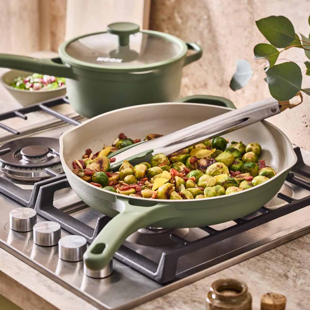 brussell sprouts being cooked in a green frypan