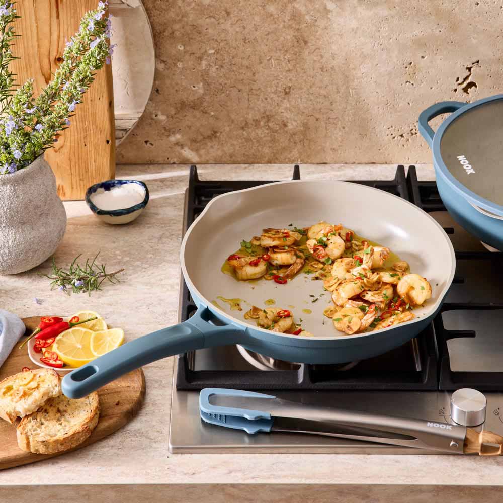 seafood marinara cooking in a blue frypan