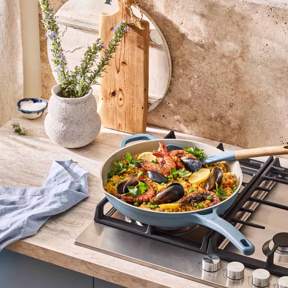 seafood paella cooked in a blue frypan on the stove