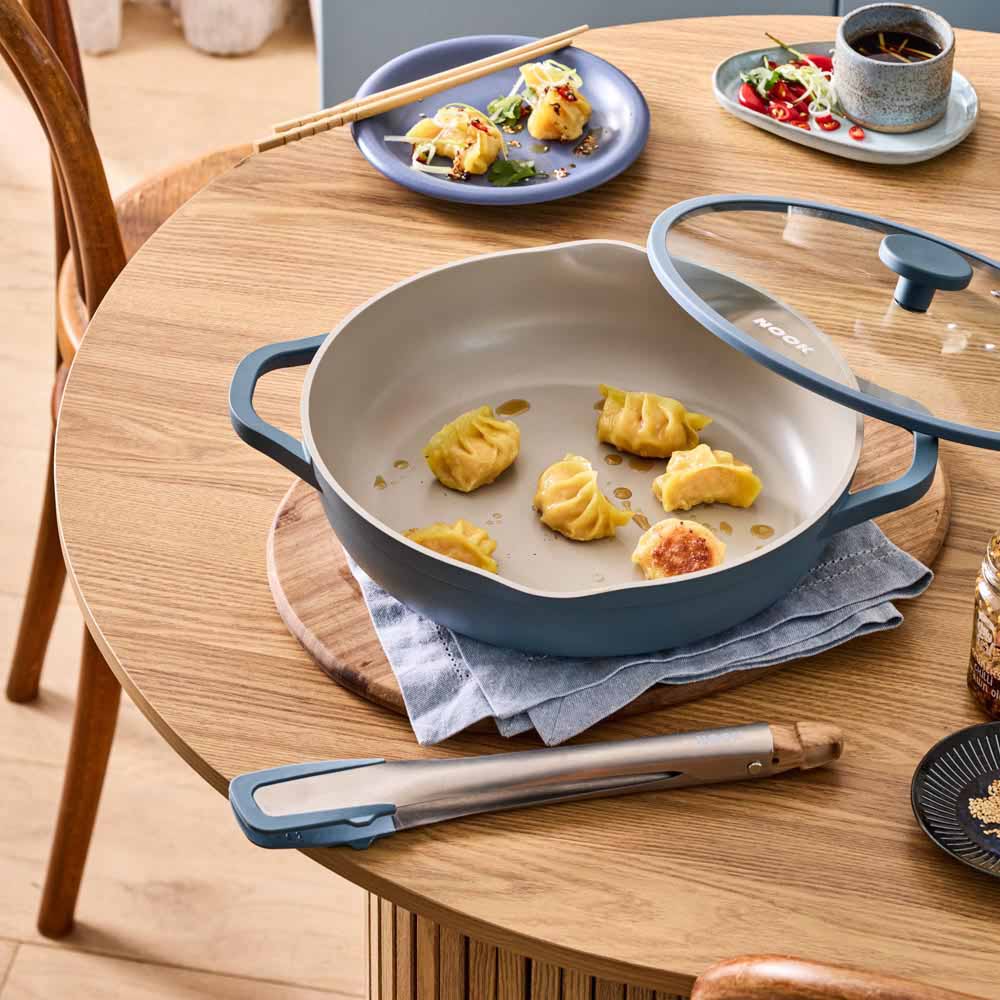 dumplings being served from blue saute pan