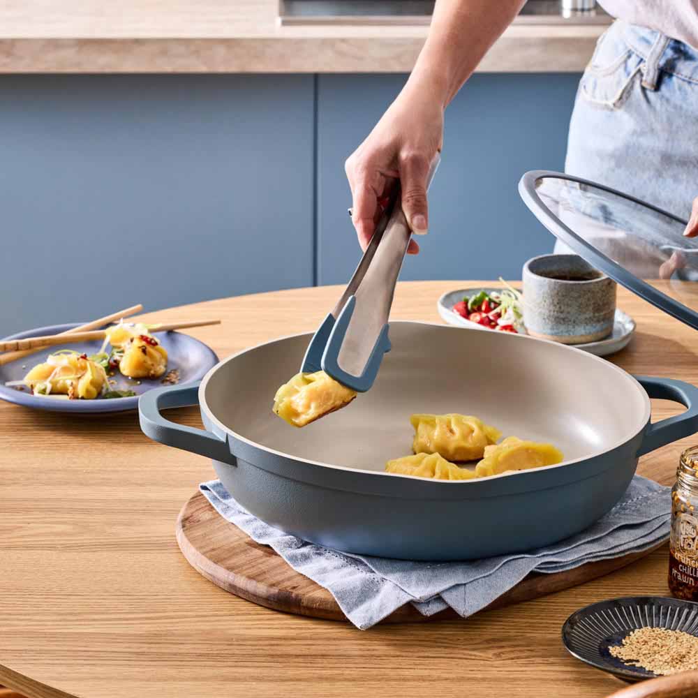 dumplings being served from blue saute pan