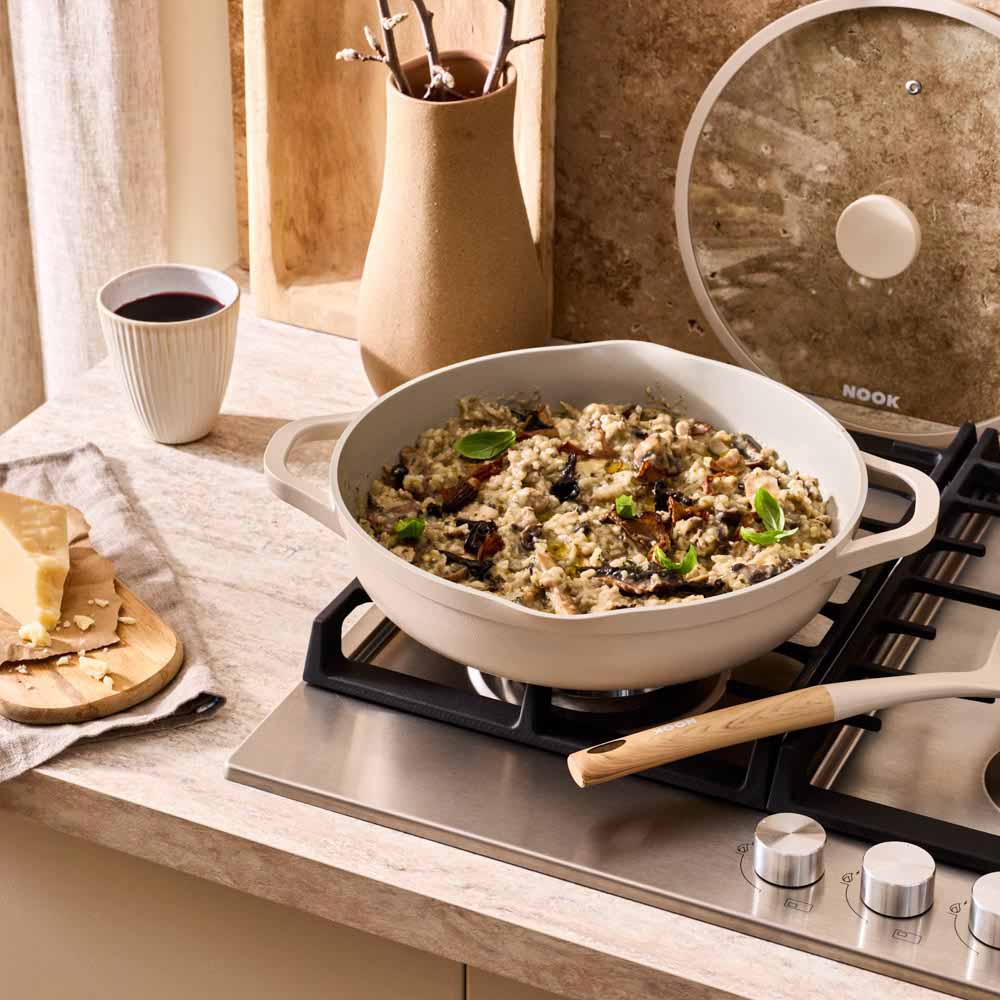 risotto cooking in a cream saute pan on the stove